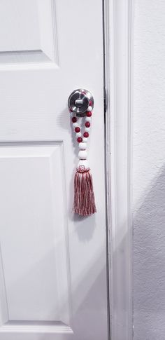 a white door with a red and white tassel hanging from it's side