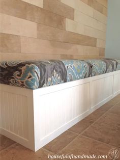 a white bench sitting in front of a wall with wood paneling on it's sides