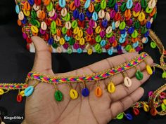 a hand holding a colorful bracelet with lots of beads