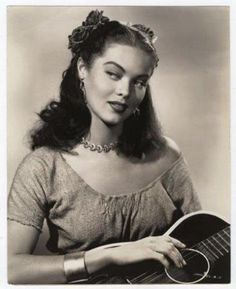 a black and white photo of a woman holding a guitar