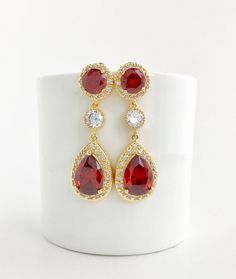 I've create this luxurious red ruby cubic zirconia bridal teardrop set in gold plated brass setting. This set includes: #Earrings feature a large teardrop with pear cut red ruby cubic zirconia center surrounded by tiny round zirconia crystals. Teardrop dangles from a earstud with brilliant cut red ruby cubic zirconia center and surrounded by tiny round zirconia crystals and a round cubic zirconia connector. Total length of the earring is 4.8 cms. #Necklace pendant features a large teardrop with Red Ruby Drop Jewelry, Ruby Drop Jewelry For Wedding, Wedding Ruby Drop Jewelry, Red Teardrop Cubic Zirconia Jewelry, Red Cubic Zirconia Teardrop Jewelry, Red Ruby Bridal Earrings For Anniversary, Red Ruby Bridal Earrings For Wedding, Red Teardrop Jewelry For Wedding, Red Teardrop Wedding Jewelry