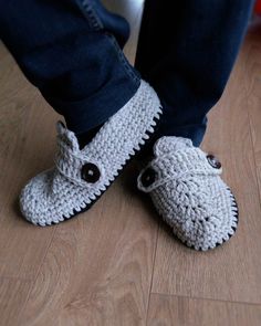 someone wearing crocheted slippers standing on the floor