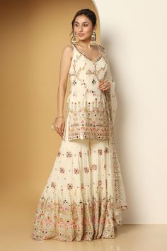 Ivory sleeveless padded short kurta in georgette base with all over mughal bloom multi color thread, zari, mirror embroideries, sequin highlights and paan neckline. Paired with a floral motif embroidered sharara and mirror border embellished net dupatta. - Aza Fashions Embroidered Sharara, Mirror Border, Kurta Sharara Set, Kurta Sharara, Short Kurta, Sharara Set, Net Dupatta, Fashion App, Set For Women