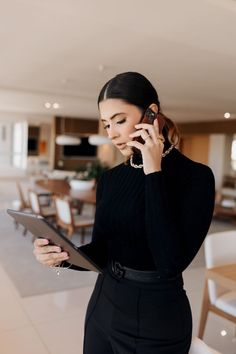 a woman talking on the phone while holding a tablet