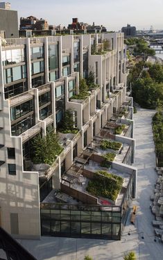 an apartment building with plants growing on the balconies