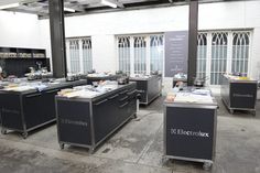 an industrial kitchen with lots of counter tops and appliances on wheels in front of windows