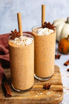 two glasses filled with pumpkin spice smoothie on a cutting board