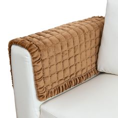 the back of a white couch with a brown blanket on it's armrest