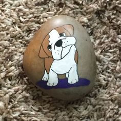 a brown and white dog painted on an egg