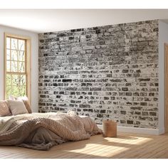 a bedroom with brick wall and wooden floors