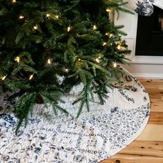 a small christmas tree in front of a fireplace with lights on the top and bottom