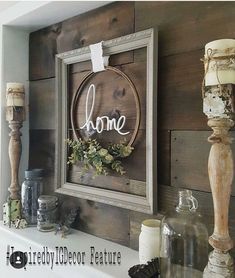 some candles are sitting on a mantle in front of a sign with the word home