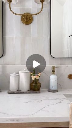 a bathroom with marble counter tops and gold fixtures on the wall, along with two mirrors