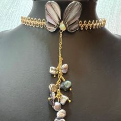 This is a beautiful one of a kind Mother of Pearl butterfly choker necklace with a pearl cluster pendant. The choker is made of a  gold wire scalloped lace design that is adjustable and will fit 14-16 inches. A shimmering dark grey carved mother of pearl butterfly wings are wrapped with 14K gold filled wire to the front of the choker. In between the two butterfly wings is a yellow nugget shaped Opal. A 3 inch length of gold figaro chain with clusters of Keshi pearls hang gently down the center o Adjustable Choker With Unique Variations As Gift, Unique Clavicle Chain Choker For Gift, Handmade Lariat Choker As Gift, Gift Clavicle Chain Choker With Dangle, Adjustable Dangle Choker As Gift, Adjustable Dangle Choker For Gift, Unique Adjustable Pearl Necklace Gift, Handmade Adjustable Pearl Necklace For Party, Handmade Adjustable Pearl Choker Necklace