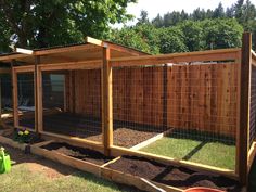 an outdoor chicken coop in the middle of a yard