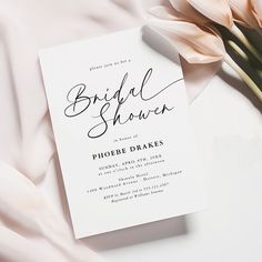 the bridal shower is set on top of a pink blanket next to a bouquet of tulips