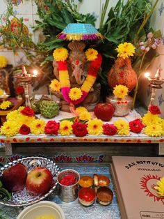 there is a small shrine with flowers and fruit on the table in front of it