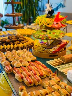 an assortment of hot dogs and other foods are on display at a buffet table in a restaurant