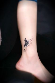 a woman's foot with a butterfly tattoo on the left side of her ankle