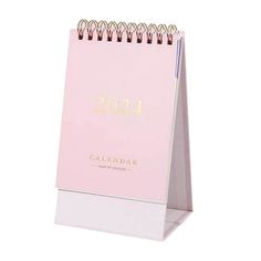 a pink and white desk calendar sitting on top of a stand