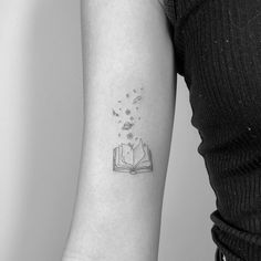 a woman with a book tattoo on her arm