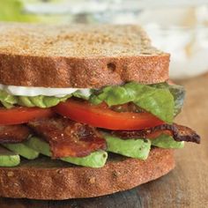 a sandwich with bacon, lettuce and tomatoes