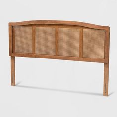 the headboard is made out of wood and has wicker panels on each side