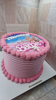 a pink cake with the word barbie on it