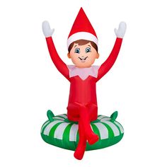 an inflatable christmas elf sitting on top of a green and white striped pillow