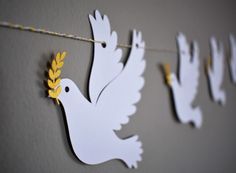 paper doves hanging on a string with yellow leaves