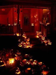 pumpkins lit up in front of a house at night