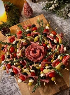 a wooden board topped with meat and veggies on skewered skewers