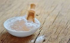 a wooden spoon filled with white powder on top of a table