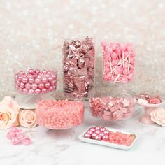 pink and white candies in glass vases on table next to hydrangeas