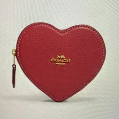 a red heart shaped purse sitting on top of a table