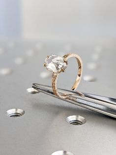 a diamond ring sitting on top of a pair of scissors