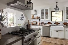 a kitchen with white cabinets and stainless steel appliances