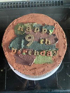 a birthday cake with the number nine on it in front of an oven door window