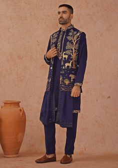 Step into sophistication with Navy Blue Jacket Kurta. Crafted from georgette, the jacket features exquisite resham and sequinned embroidery. This elegant ensemble includes a yoke design kurta, pure lining, and two pockets. Completed with an embroidered dupatta and matching pants. Perfect for special occasions like Sangeet, Mehendi, or as a wedding guest outfit. Composition : Jacket, Kurta & Trouser : Viscose Georgette Care: Dry Clean Only and Vacuum Storage This product can be customized for sle Kurta Set With Jacket, Design Kurta, Yoke Design, Vacuum Storage, Navy Blue Jacket, Indian Wedding Wear, Embroidered Dupatta, Matching Pants, Kurta Designs