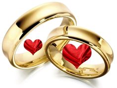 two gold wedding rings with red hearts on the inside, and one in the middle