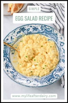 an egg salad in a blue and white bowl with a spoon on the plate next to it