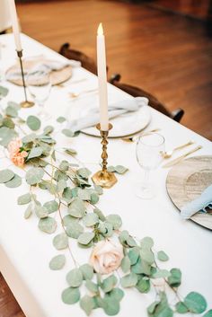 the table is set with candles, plates and napkins for an elegant wedding reception