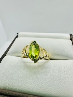 This unique and beautiful 10 karat Yellow Gold Marquise Peridot Stone measures 10 mm in length and 5 mm in width. Total weight of the ring is 2.04 grams.  Ring is a size 7 and stamped "10K" and "W". All items arrive wrapped carefully for shipping and in a gift box. Fine Jewelry Lime Green Gemstone, Fine Jewelry In Green Peridot, Green Peridot Fine Jewelry, Fine Green Peridot Jewelry, Green 14k Gold Ring With Accent Stones, 14k Gold Green Rings With Accent Stones, Green 14k Gold Rings With Accent Stones, Lime Green Gemstone Ring Jewelry, Lime Green Gemstone Ring