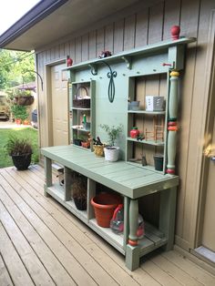 an outdoor garden bench with potted plants and gardening tools on it's shelf