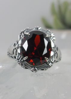 "Red Garnet Ring (Choose Garnet CZ or a Natural Red Garnet Gemstone) Beauty Design#229 MADE TO ORDER Ring Description This is a brand new stunning Art Nouveau/Victorian reproduction sterling silver filigree ring. The flawless oval-cut high-quality 5ct Red Garnet gemstone is 12mm by 10mm (just shy of 3/8\" inch) in dimension. (Choose between a Red Garnet CZ or a Natural 5ct Natural Garnet (VVS)). The ring is 5/8th of an inch (16.5mm) NS (long) on the finger. The ring and gem sit 7mm off the finge Red Ruby Ring With Intricate Design, Red Filigree Ruby Ring For Gift, Red Ruby Filigree Ring As Gift, Red Ruby Ring With Filigree For A Gift, Oval Engraved Red Ruby Ring, Oval Engraved Ruby Ring, Oval Ruby Ring With Engraving, Oval Ruby Ring Engraved, Victorian Red Ruby Ring In Sterling Silver