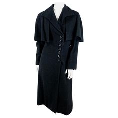 1930s black wool coat featuring an A-line silhouette, full length sleeves, a sting-ray collar and an attached capelet. The front closure has a series of black art deco buttons that match the rows of buttons on the back of each sleeve. The coat is fully lined in black silk. Fitted Black Wool Coat For Evening, Wool Evening Outerwear With Buttons, Evening Wool Outerwear With Buttons, Black Evening Wool Long Coat, Vintage Fitted Cape Outerwear, Vintage Wool Coat With Buttons For Formal Occasions, Vintage Formal Wool Coat, Capelet Coat, Brown Wool Coat