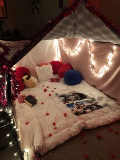 a bed that has been decorated with red and white lights on the headboard, along with other decorations