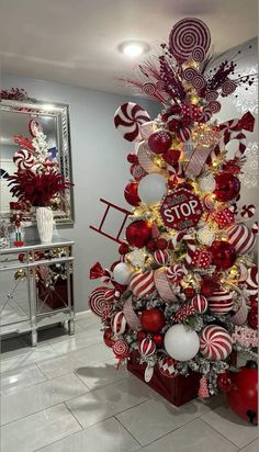 a christmas tree decorated with candy canes and lollipops in red, white and gold