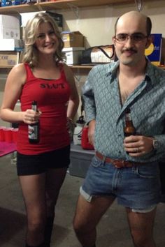 a man and woman standing next to each other in front of a table with bottles on it