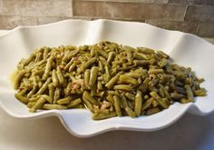 a white bowl filled with green beans on top of a table